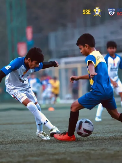 Two players battling for possession in a tightly contested match.