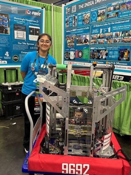 Student Vihaana Desai stands with her team's ingeniously engineered robot at the FIRST World Championship, a project that stunned the judges.