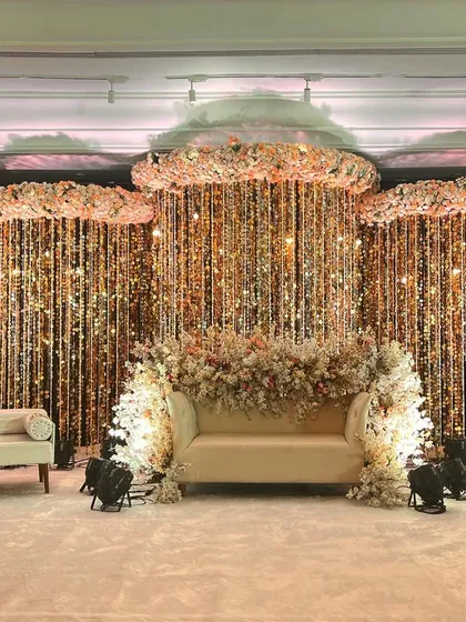 To create a truly showstopping reception, I designed this stage with clouds of baby's breath and a cascading curtain of glittering crystals. The lighting and floral arrangements work together to produce an ethereal and unforgettable backdrop for the couple.