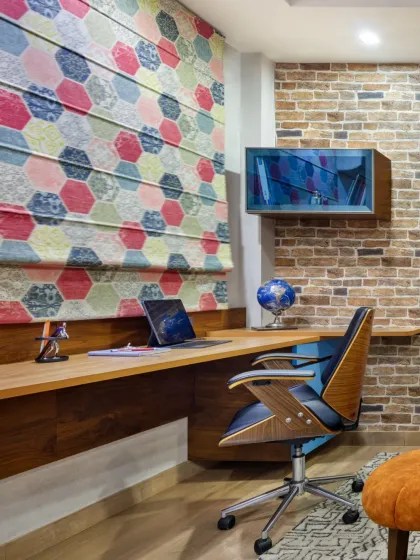 A closer look at the cantilevered workstation in the Rue 32 den. Paired with a vibrant hexagonal-patterned roman blind and an ergonomic chair, this custom desk is designed for productivity and comfort in a compact, multi-functional space.
