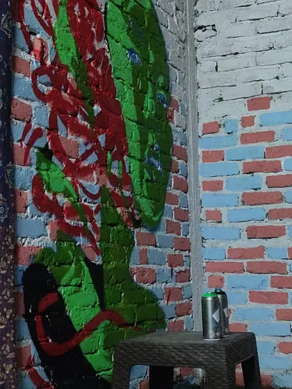 Another shot of the "Queen of Hearts" themed mural in Pulga. The exposed brick wall adds a great texture to the artwork, blending raw street style with an indoor setting.