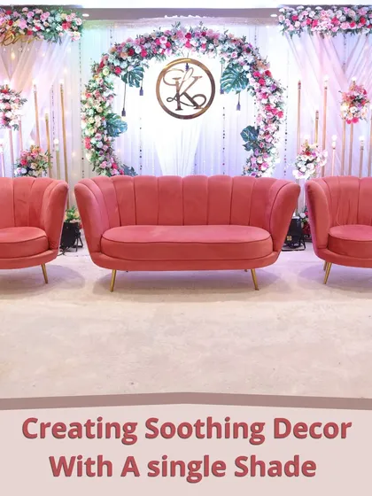 Creating a soothing and elegant look with a single shade. This reception stage features blush pink seating against a floral arch and monogram, showing the power of monochromatic design.