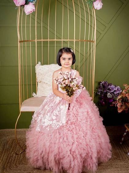 For this shot, we used our golden birdcage chair and a soft green backdrop. The combination of the pink gown and the set creates a lovely, garden-party feel for this kid's portrait.