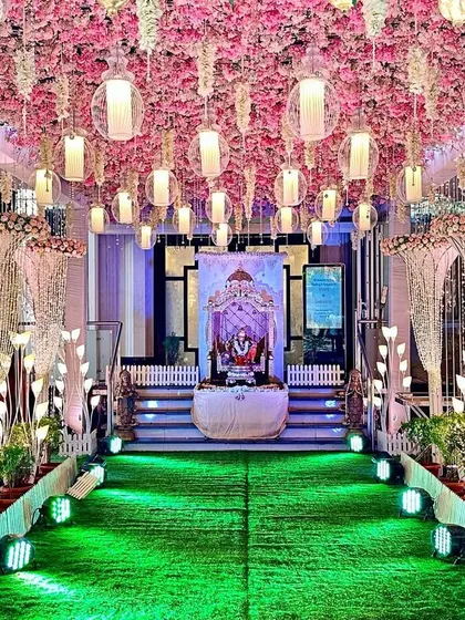 A pretty entrance decor with a ceiling of pink cherry blossoms and hanging lanterns. This design is ideal for creating a classy and romantic atmosphere for night functions like a reception or Sangeet.