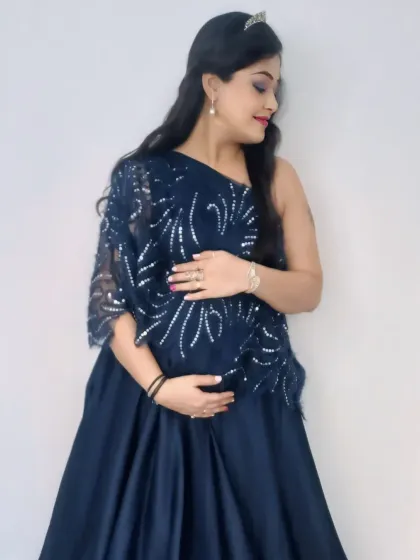 Elegant and refined, this navy blue gown features a one-shoulder design with intricate silver sequin detailing on a delicate lace overlay.