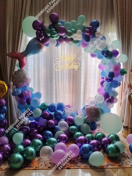 A mermaid theme for a 6th birthday, featuring a large balloon ring and number foil balloon.