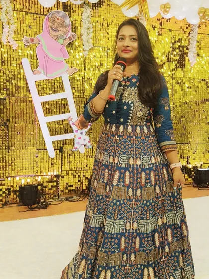 Holding the mic against a festive backdrop for the Swarna Sidi ceremony. The decor, with its bright colors and traditional elements, perfectly complemented the joyous occasion.