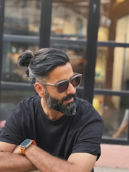 The man bun look, executed with a sharp undercut. This style keeps the sides and back neat and tidy while allowing for length and styling versatility on top.