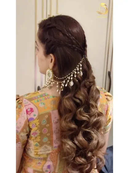 A half-up style with braids and curls, adorned with beautiful shell and pearl hair jewellery.