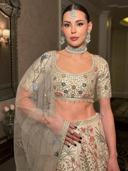 Another angle of this stunning international muse. The makeup is clean and elegant, with a perfectly defined brow and neutral tones that complement the intricate embroidery of her lehenga.