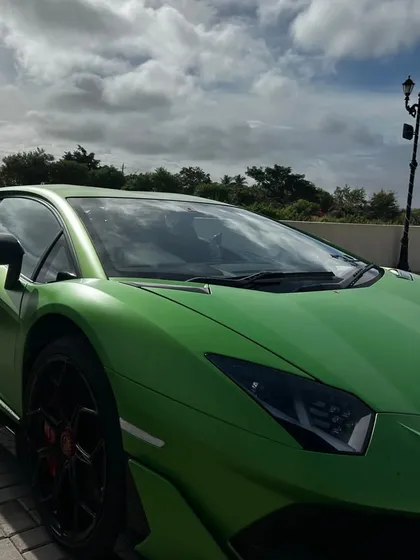 A close-up of a stunning matte green Lamborghini Aventador, a frequent and welcome sight at our highway stop, attracting car spotters and fans.