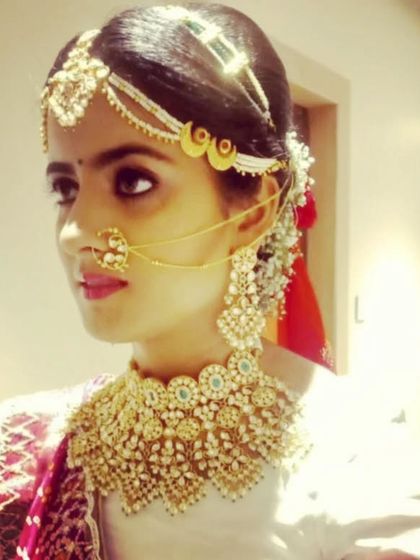 A regal look featuring a heavy, collar-style Kundan necklace and an elaborate matha patti. This is perfect for the bride who wants to make a grand statement.