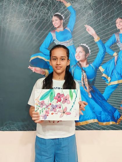 This talented student proudly holds up her beautiful floral watercolor painting. Our classes help young artists explore different mediums and find their favorite style.