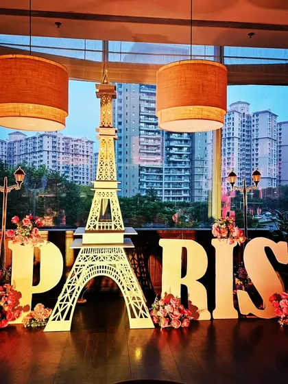 A high-quality shot of the Paris decor at The Quorum club. The large props stand out beautifully against the modern interior and the city view from the window.