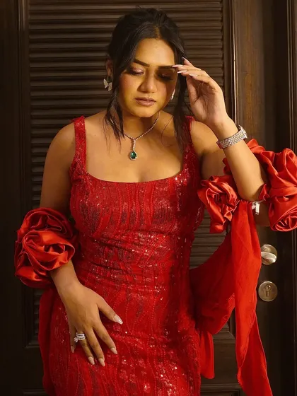 Feeling powerful in this stunning red sequin gown with dramatic ruffled sleeves. Red is the color of celebration, and this dress is perfect for making a statement.