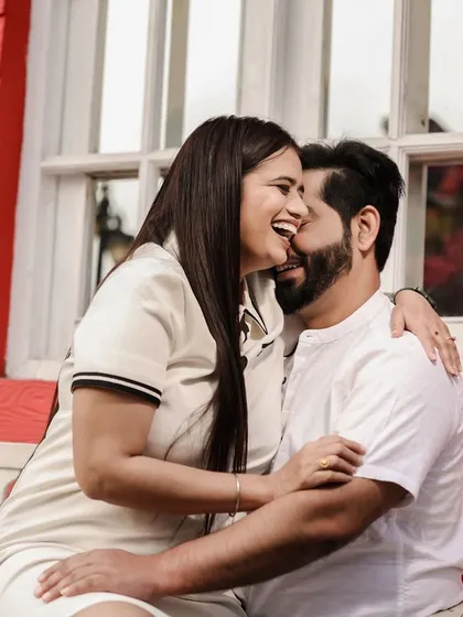 A pre-wedding shoot should be fun and reflect your personality. This candid photo captures a moment of pure, uninhibited laughter between the couple. The relaxed setting and their genuine smiles show a different, more playful side of their relationship.