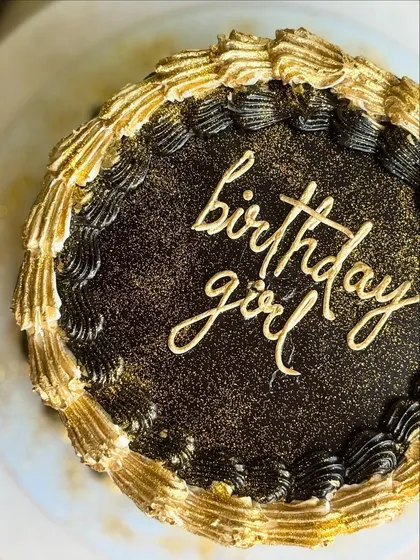 Black, bold, and baked to impress. A dramatic black and gold birthday cake for a girl who is not average.