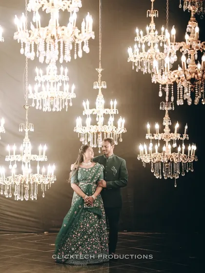 A glamorous pre-wedding portrait in a studio filled with dozens of sparkling chandeliers, creating a magical and luxurious atmosphere for this elegantly dressed couple.