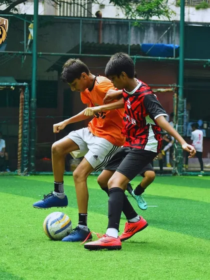 A tough battle for the ball, showcasing the competitive spirit of our young players.