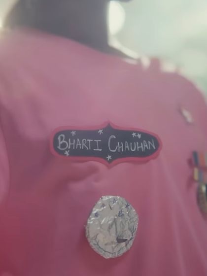 A detail shot of the DIY name tag and medals on the child's uniform. These small, handcrafted elements were essential for showing her creativity and the personal start of her dream to join the army.
