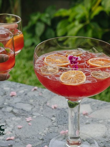 Our Sakura cocktail is a community drink, perfect for sharing. It's a refreshing blend of gin, sake, and fruit juices, beautifully presented in a large bowl.