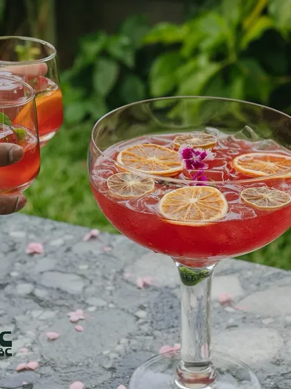 Our Sakura cocktail is a community drink, perfect for sharing. It's a refreshing blend of gin, sake, and fruit juices, beautifully presented in a large bowl.