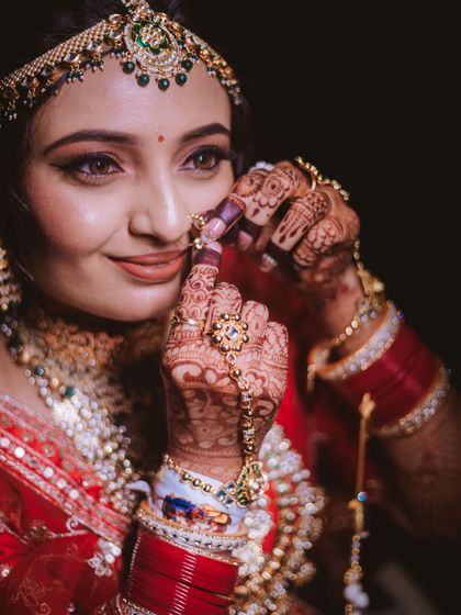 A candid moment of the bride adjusting her nath. These small details make the bridal look so special.