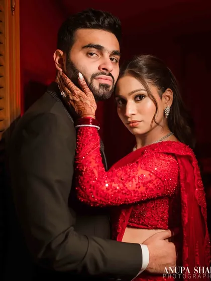 A bold and stylish portrait with dramatic red lighting. The couple's intense gaze and close embrace create a powerful, fashion-forward image perfect for a cocktail party or reception.