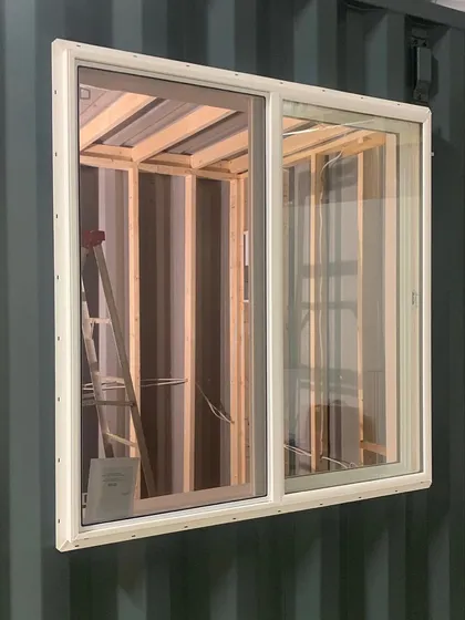 The customization process begins. Here, we are installing a large sliding window into a 20-foot container, the first step in converting it into a sound-proofed music studio for a client. If you can dream it, we can build it.