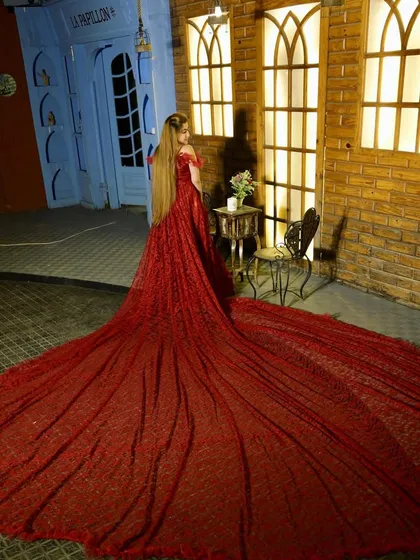 Make your fairytale dream come true with this magnificent red sequined trail gown. The train is incredibly long and wide, covered in sparkles to create a truly show-stopping effect for any photoshoot.