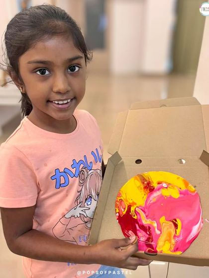 This young artist is so proud of the vibrant yellow and pink fluid art piece she created. It's amazing to see their confidence grow.