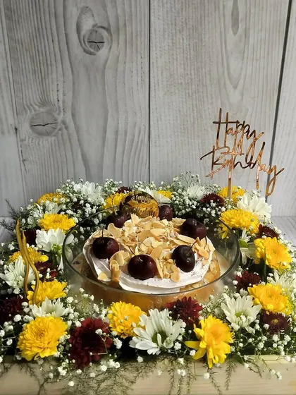 Make their birthday truly special with a complete celebration in a box. This floral hamper features my moist Cherry Almond Tres Leches cake, surrounded by a bed of fresh, vibrant flowers and topped with a custom birthday message.