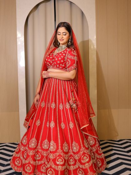 A confident pose in the red bridal lehenga. My goal is to make every bride feel comfortable and beautiful in her own skin.