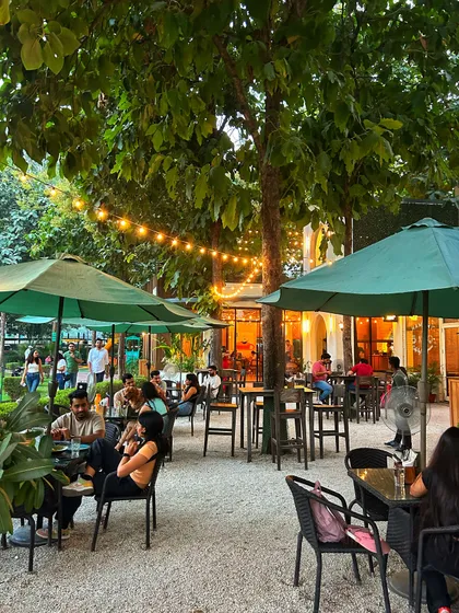The cafe patio is a hub of activity, with guests enjoying food, drinks, and conversation.