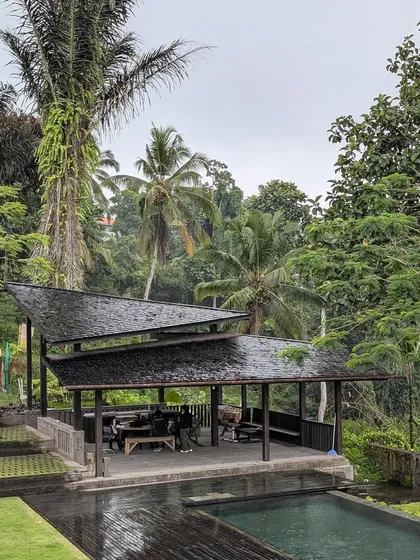 A poolside pavilion we designed in Bali, surrounded by lush jungle. The multi-layered roof provides shade and protection from the rain while remaining open to the breeze, creating a perfect indoor-outdoor living space.