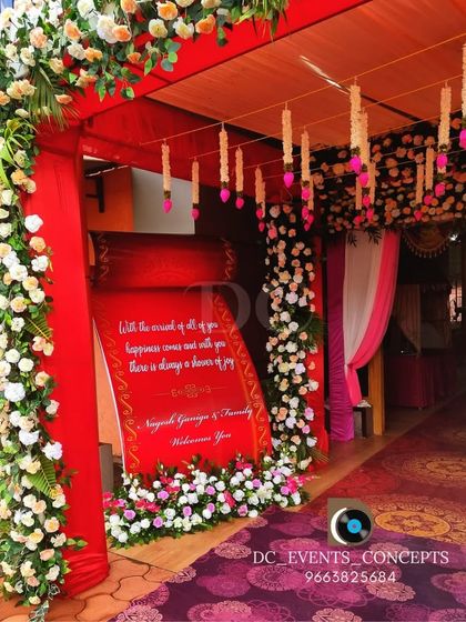 A closer look at a vibrant red-themed entrance. The personalized welcome scroll and hanging floral tassels add intricate details that make the entryway special and inviting.