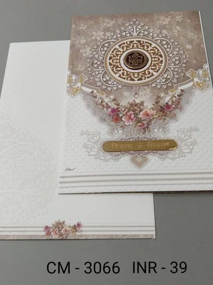A beautiful invitation with a detailed mandala design and floral accents. The card has a classic and intricate look, perfect for a traditional wedding.