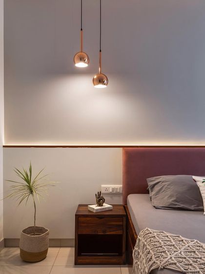 This bed back wall is a great example of cost-effective elegance. A simple painted wall is elevated with a thin strip of profile lighting, creating a sophisticated ambient glow above the mauve headboard.