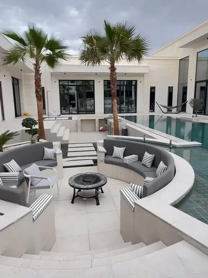 Our landscaping services extend to high-end residential properties. Here, we integrated palm trees and a sunken lounge area into a modern poolside, creating a luxurious and seamless indoor-outdoor living space.