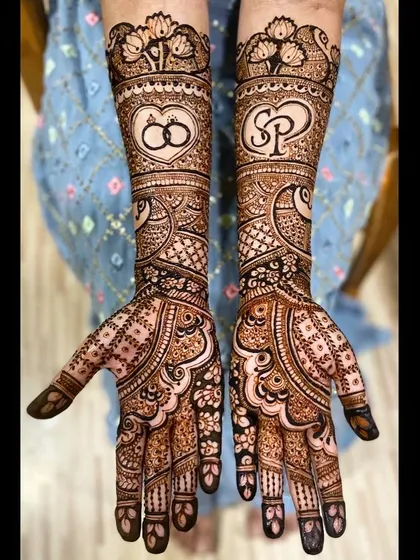 A classic design featuring intertwined wedding rings on one arm and the couple's initials, 'SP', on the other, surrounded by beautiful paisley patterns.