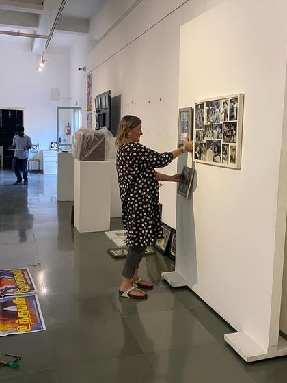 Clare Arni adjusting the placement of works on a temporary wall.
