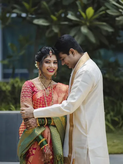 A classic pose with a modern feel. This portrait of Roshan and Meenakshi showcases her beautiful bridal saree and the groom's elegant attire, capturing a moment of quiet affection between them.