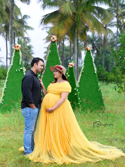 A sweet couple's portrait with our unique cone-shaped green props. The mother-to-be is wearing a lovely yellow gown.