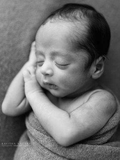 A nine-day-old newborn in a classic curled-up pose, captured in timeless black and white. The simplicity of the shot makes it powerful and mesmerizing.