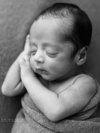 A nine-day-old newborn in a classic curled-up pose, captured in timeless black and white. The simplicity of the shot makes it powerful and mesmerizing.