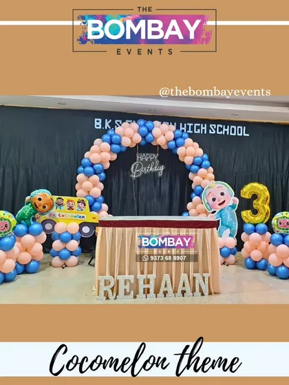 Another fun Cocomelon setup, this time with a semi-arch over the cake table. The design includes character cutouts, a number '3' foil balloon, and the birthday boy's name in light-up letters.