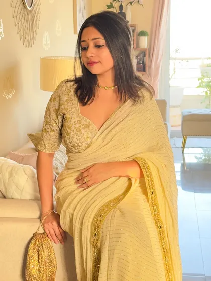 A final shot of the golden saree look, showing the full effect of the outfit in a relaxed, seated pose. It’s all about feeling comfortable and beautiful in what you wear.
