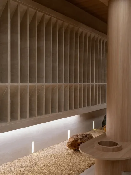 A close-up of the textured wall and the integrated seating, showing the seamless fusion of form and function.