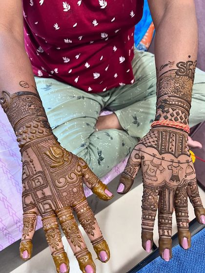 A different style of baby shower mehendi, with the baby's initial 'SH' and other personalized elements.