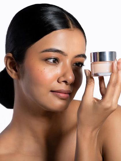 A clean, product-forward shot where the model holds the jar up for inspection. This composition is ideal for e-commerce and product pages, as it clearly displays the packaging and the product's color and consistency.